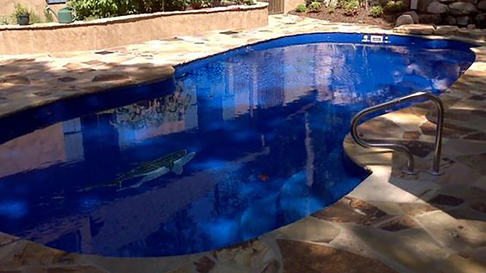 Alaglas Pools' Grand Baron, a large, freeform fiberglass pool in sapphire blue